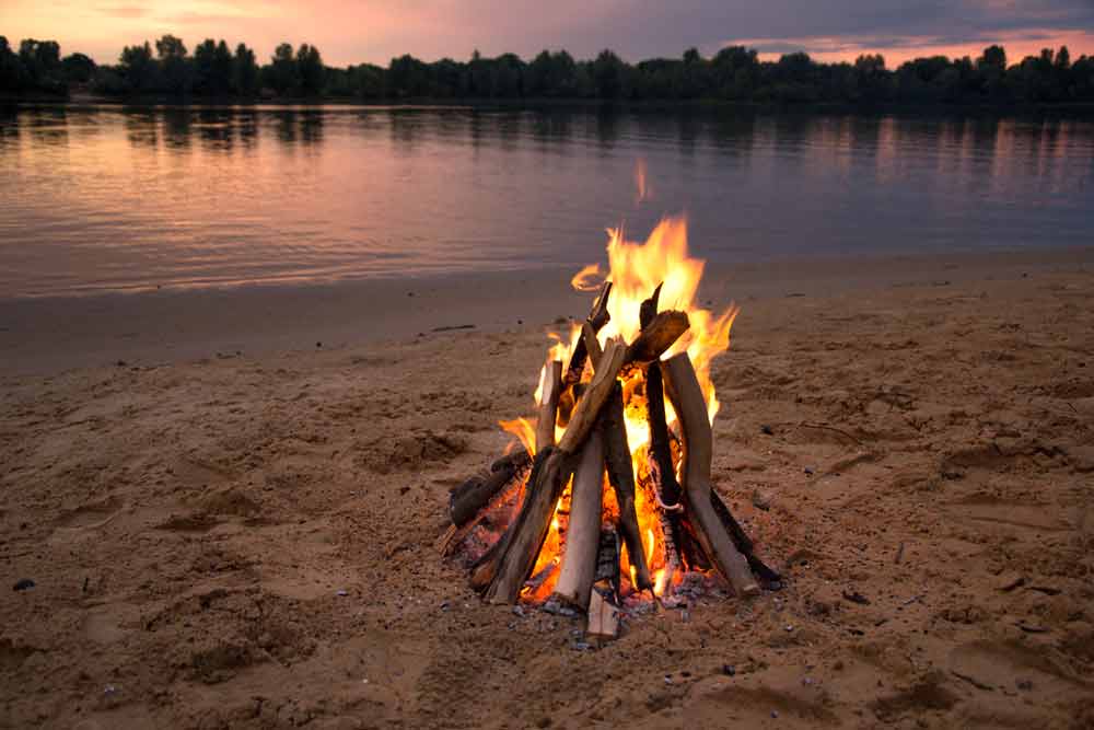 Bonfire on sandy beach in the evening